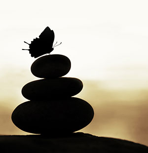 A stack of stones with a butterfly resting on top